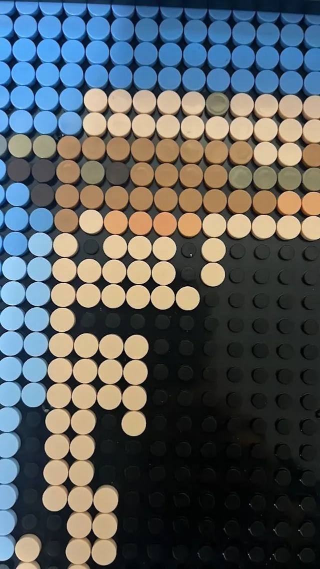Detalle del mosaico a medio montar: las primeras filas de piezas sobre la placa negra