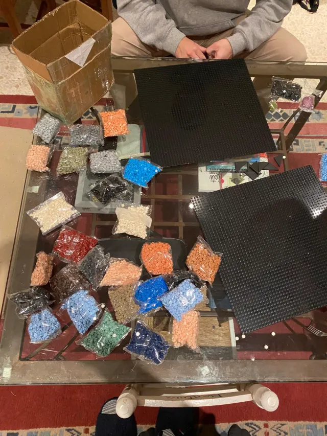 Montaje del mosaico sobre la mesa, con las placas base y las bolsas de piezas por colores