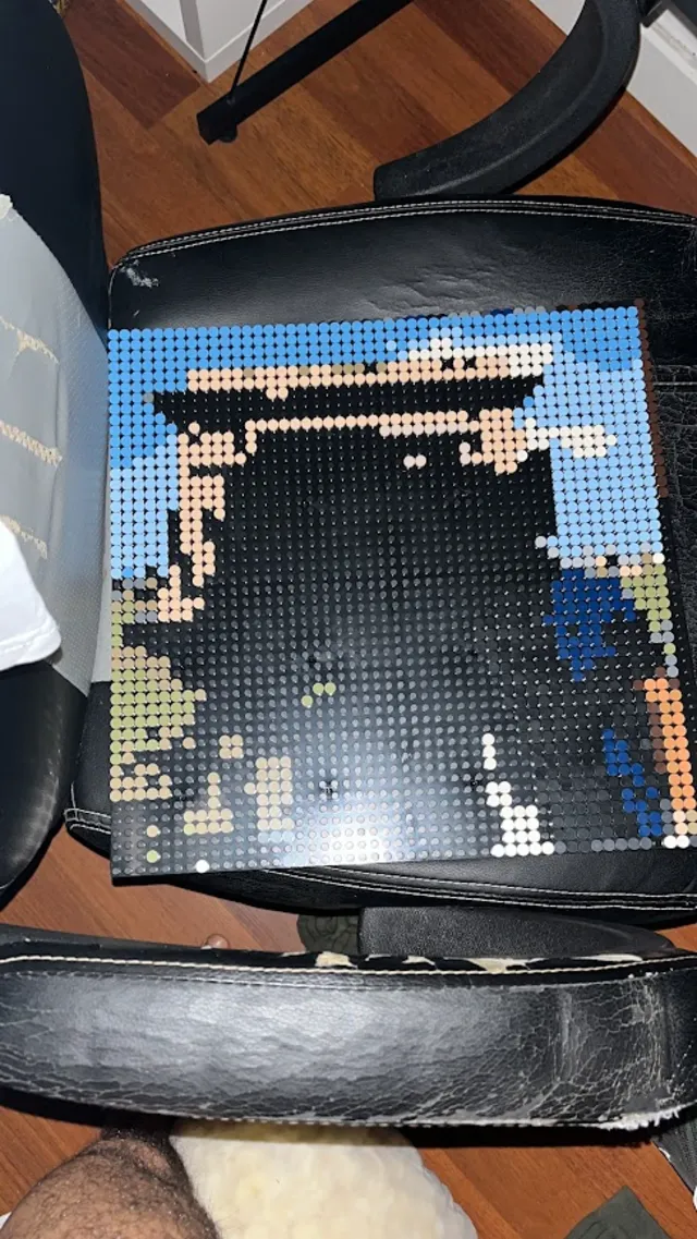 Mosaico de piezas a medio montar apoyado en el respaldo de una silla