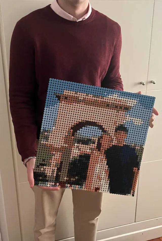 Mosaico de piezas terminado de una foto de madre e hijo, sostenido en las manos