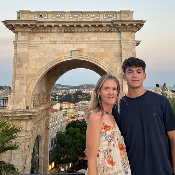 Foto original: una madre y su hijo abrazados delante de un arco de piedra
